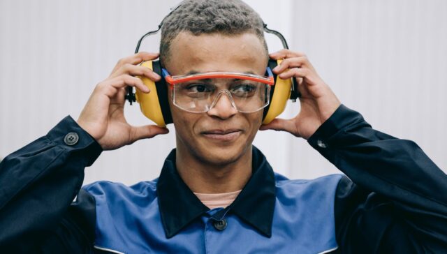 Trabajador colocándose protectores auditivos y gafas de seguridad