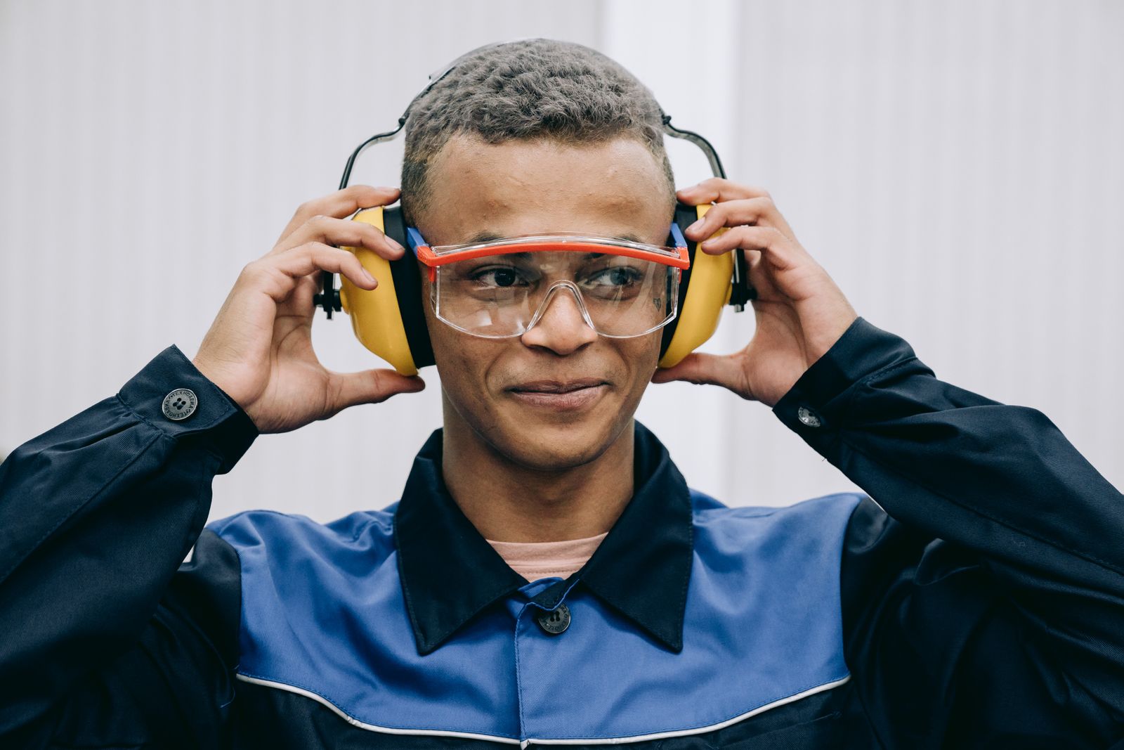 Trabajador colocándose protectores auditivos y gafas de seguridad